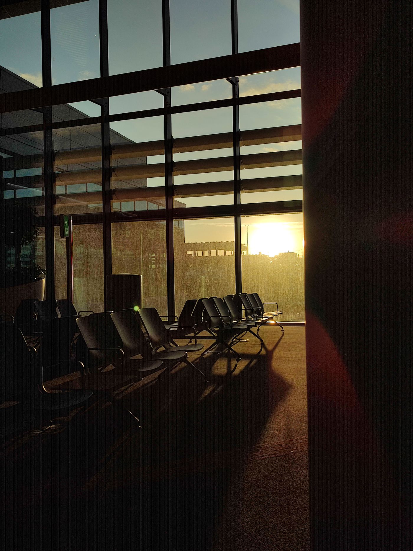 Airport lounge seating by windows at sunrise