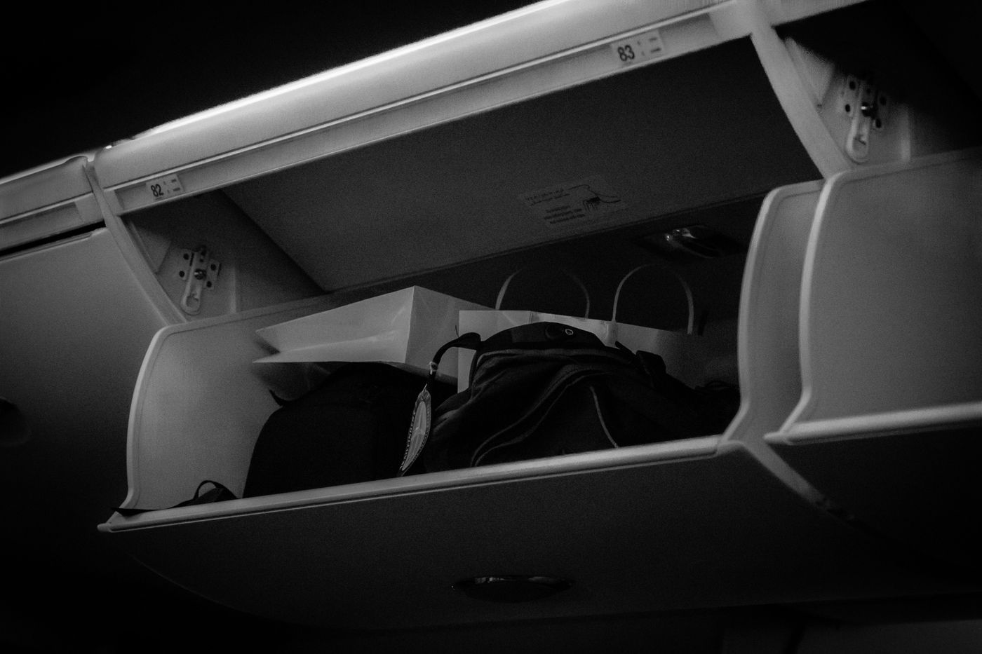 Open overhead bin with carry-on bags on an aircraft