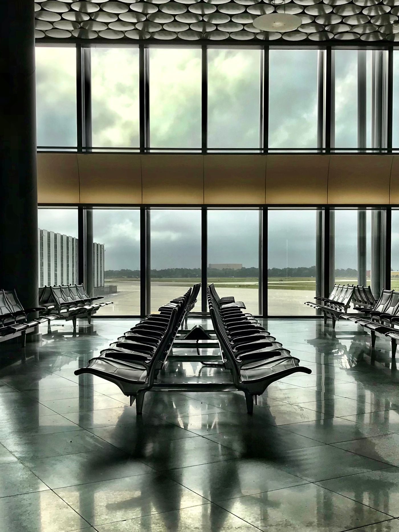 Empty airport gate seating facing the tarmac during a layover